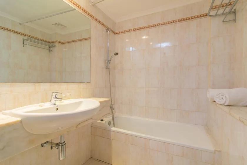 A tiled bathroom with a sink and bathtub.