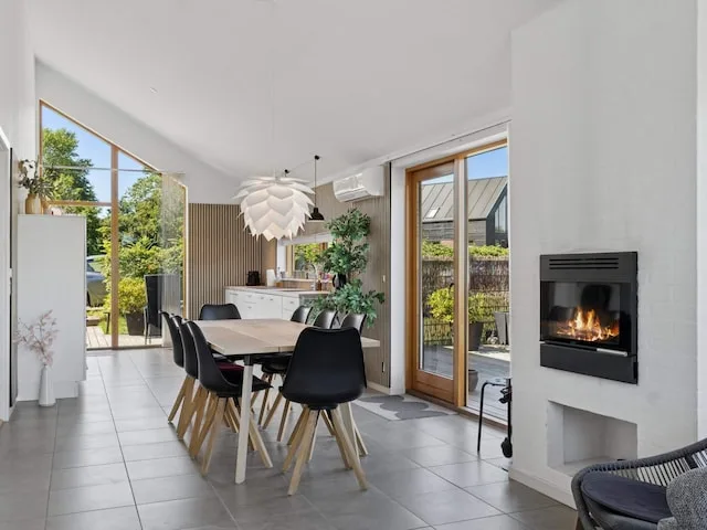 A bright dining area with a table and large windows opening onto a patio.