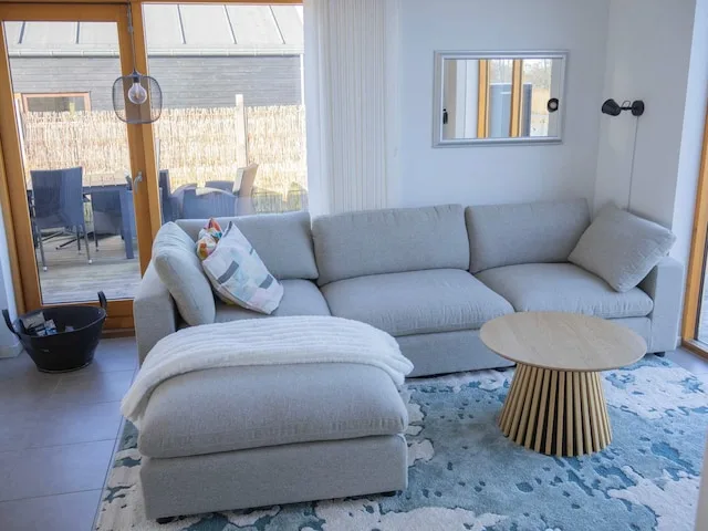 A bright living room with gray seating and a round coffee table.