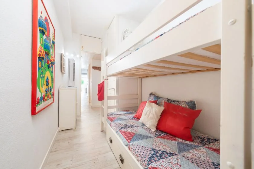 Una zona de descanso compacta con una litera y ropa de cama colorida.