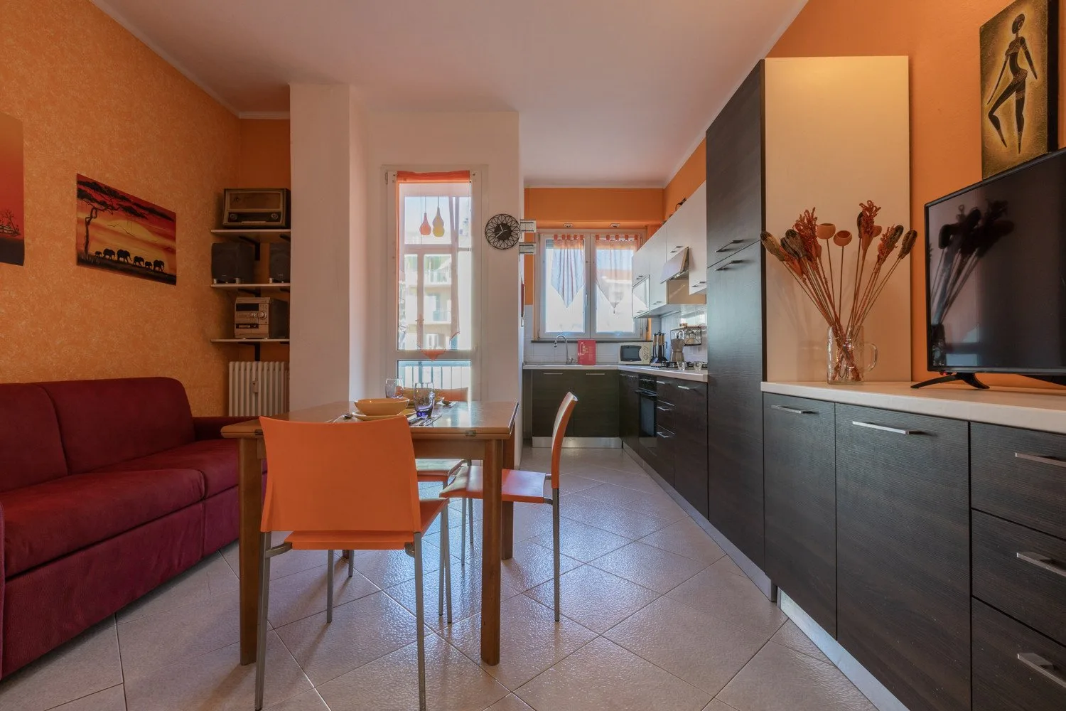 Un comedor se abre a una cocina, con una mesa y sillas.