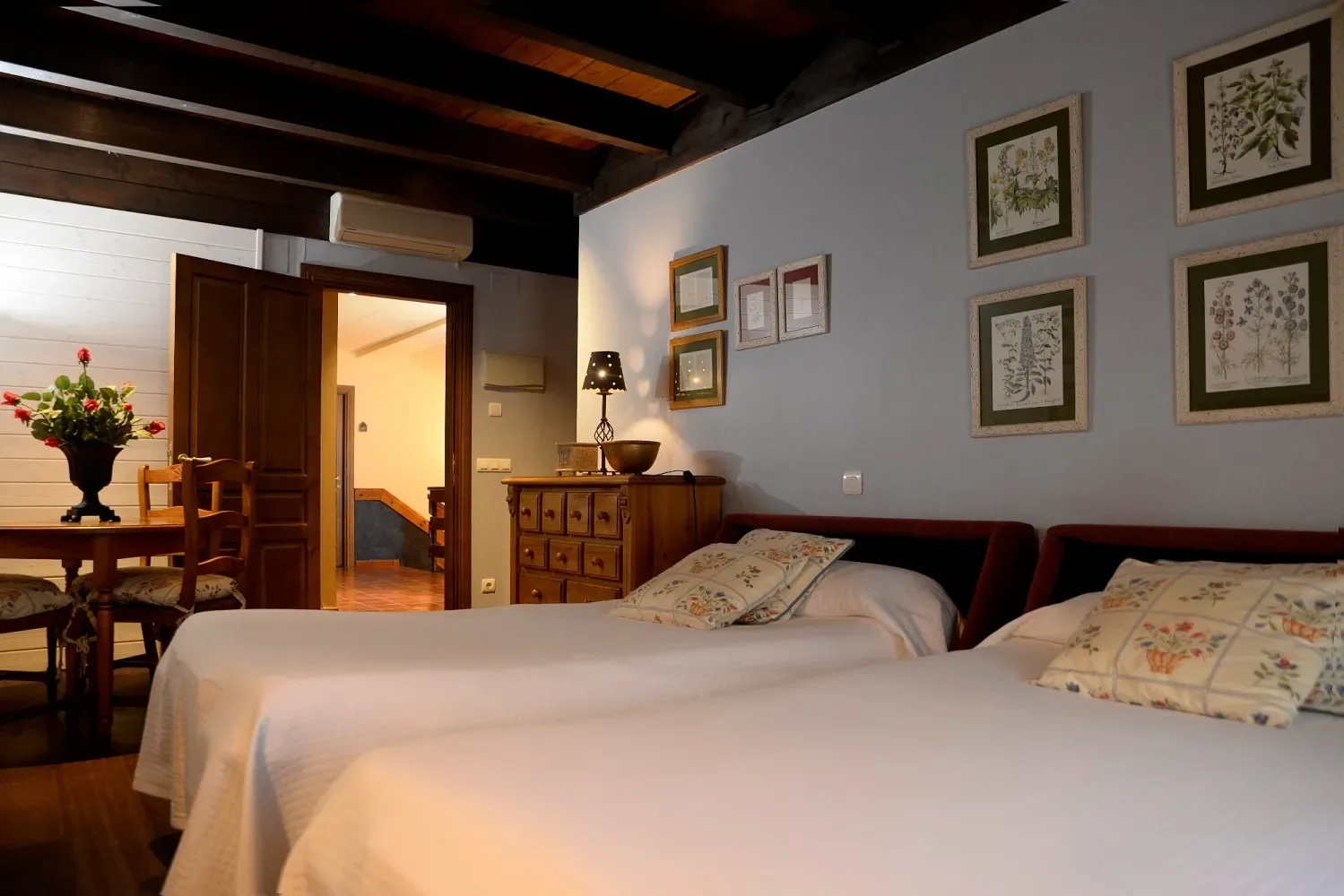 Dormitorio con dos camas individuales, paredes azules y muebles de madera.