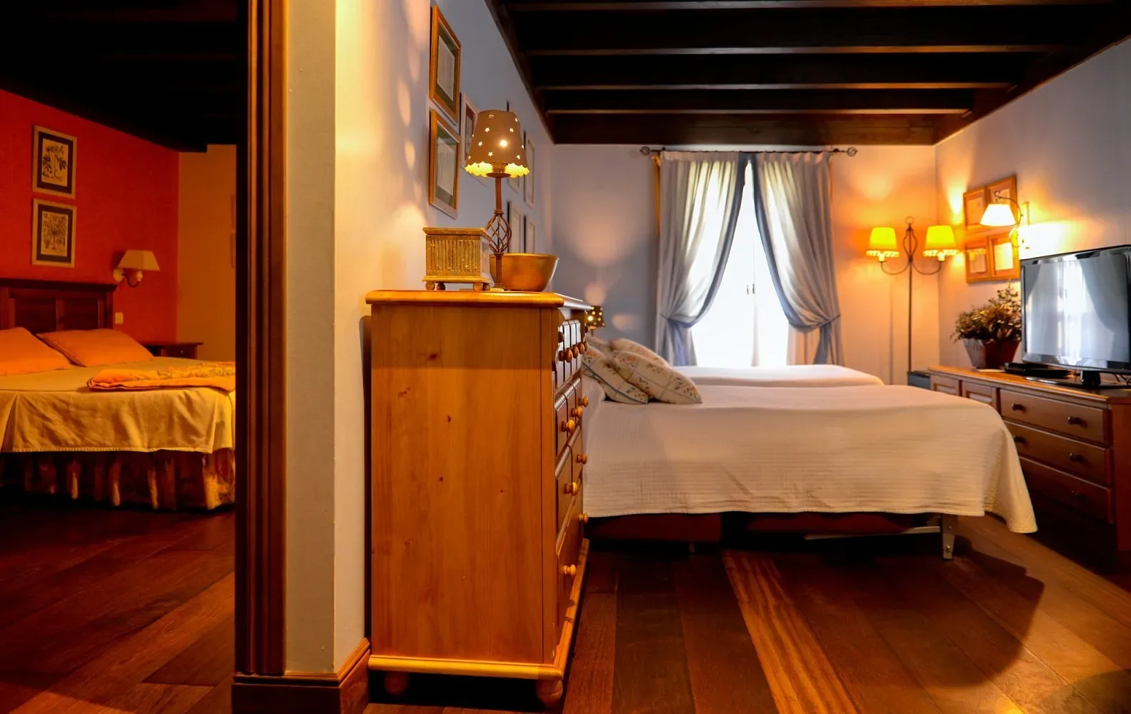 Dormitorio amueblado en madera con dos camas y televisor.