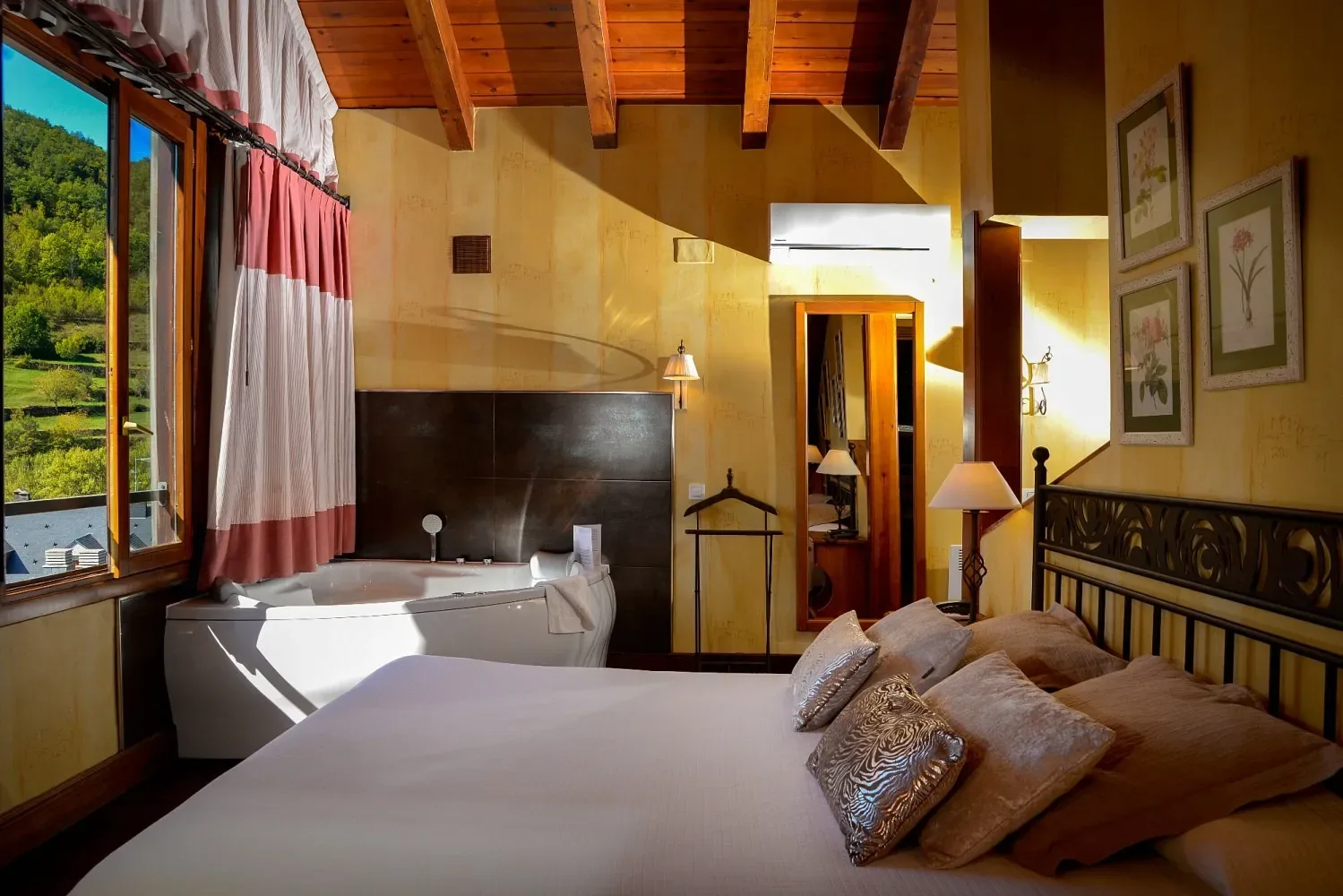 Dormitorio con cama, jacuzzi y una ventana con vistas a las montañas.