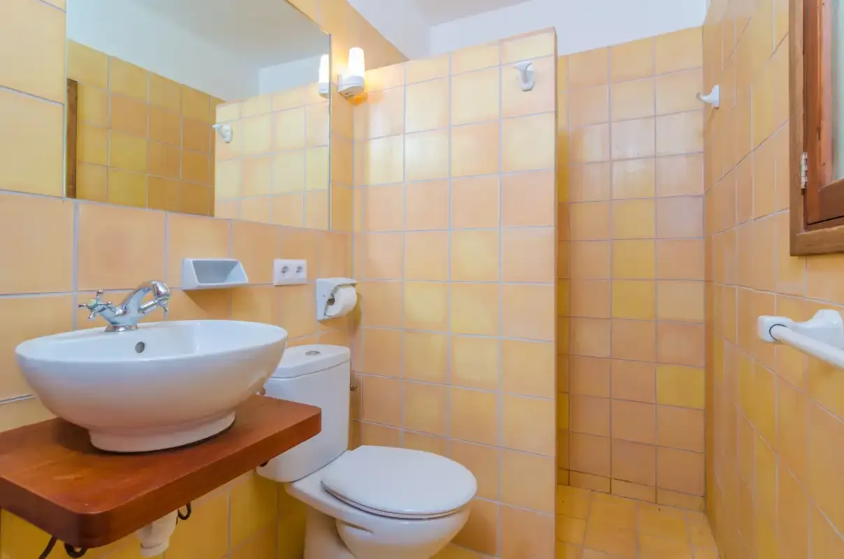 Un baño con azulejos, lavabo, inodoro y ducha.