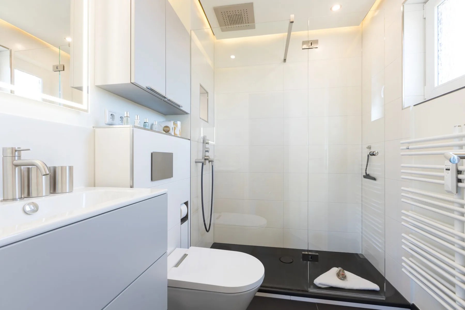 A bright bathroom with a bathtub, sink, and glass shower area.