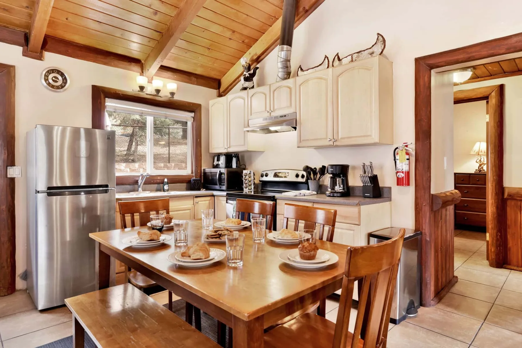 A kitchen with a wooden dining table set in front of the counters.