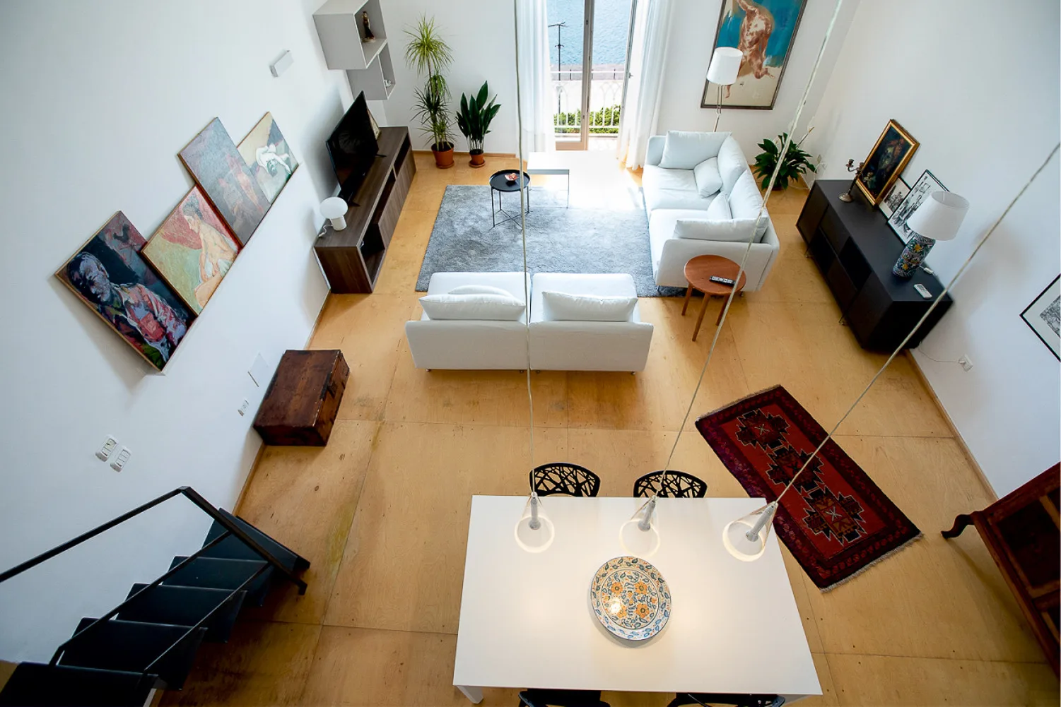 A bright living and dining area with seating, a television, and a dining table.