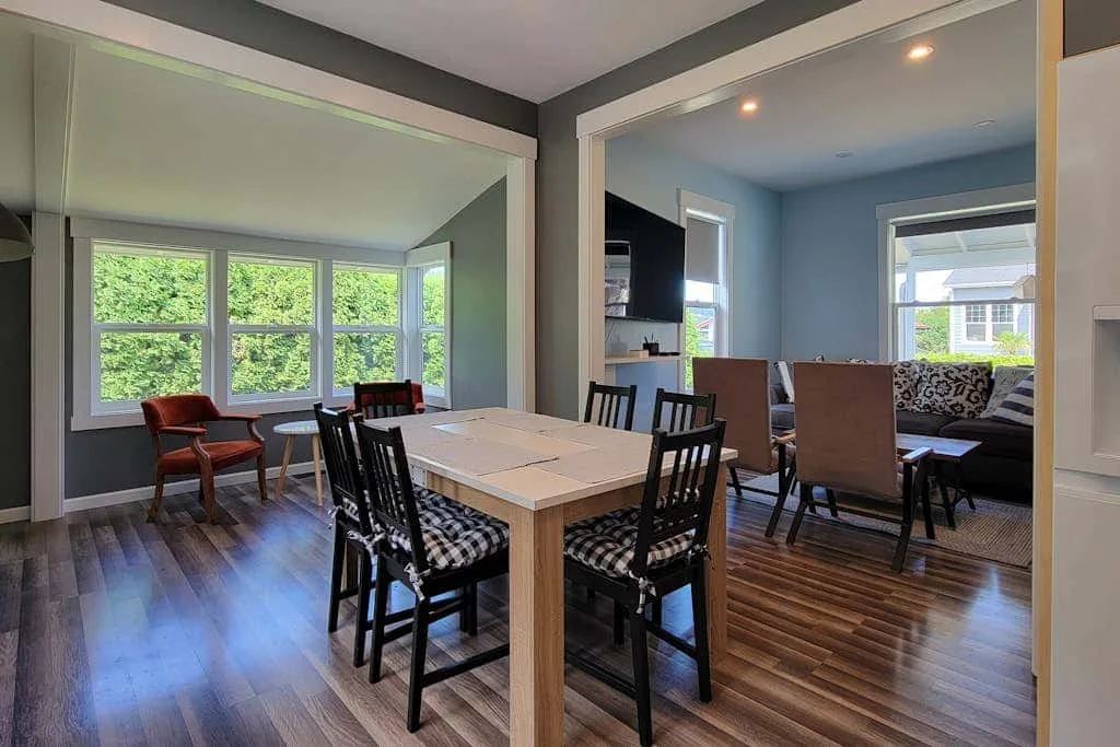 A dining area with a table and chairs beside a bright living space.