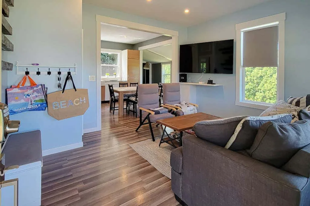A living room with gray seating, a wooden coffee table, and a television.