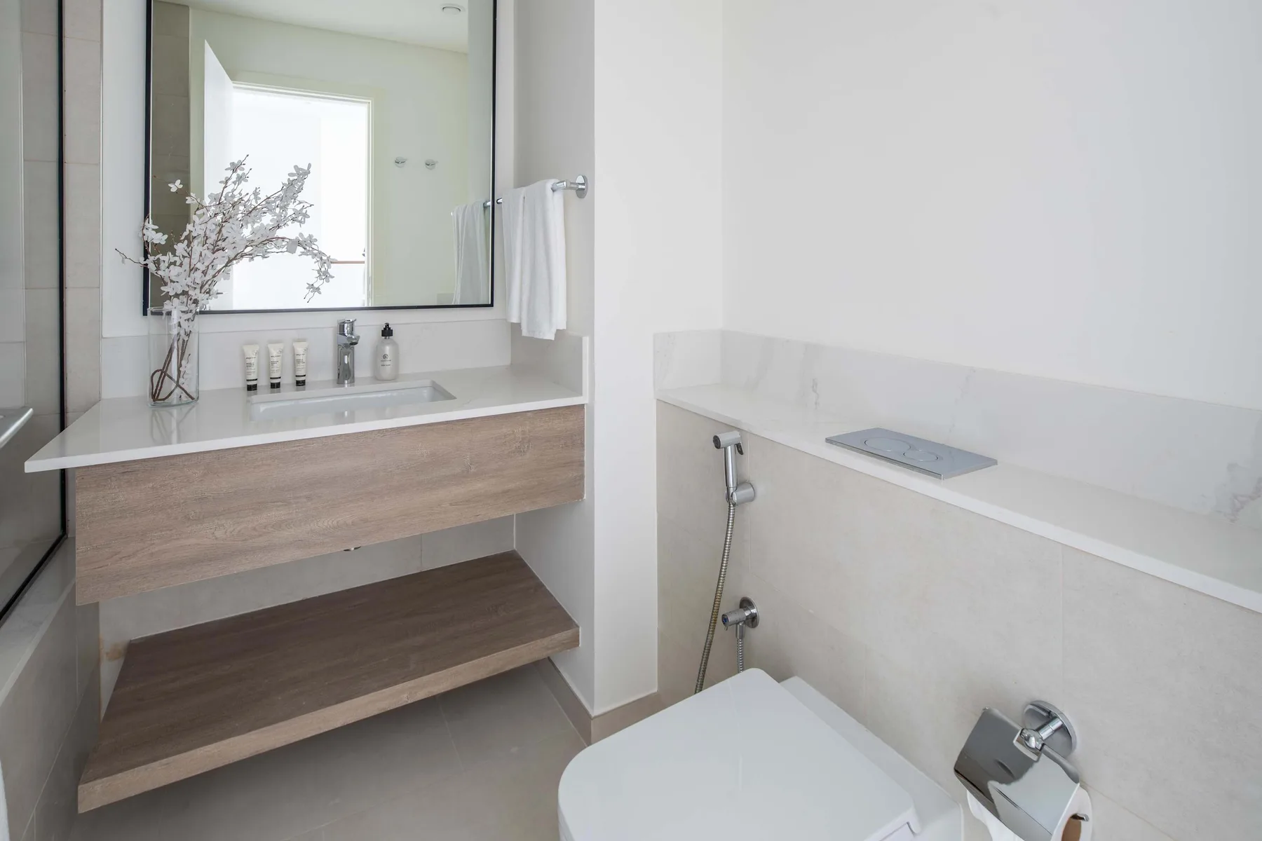 Bathroom with a sink vanity, mirror, and shower area.
