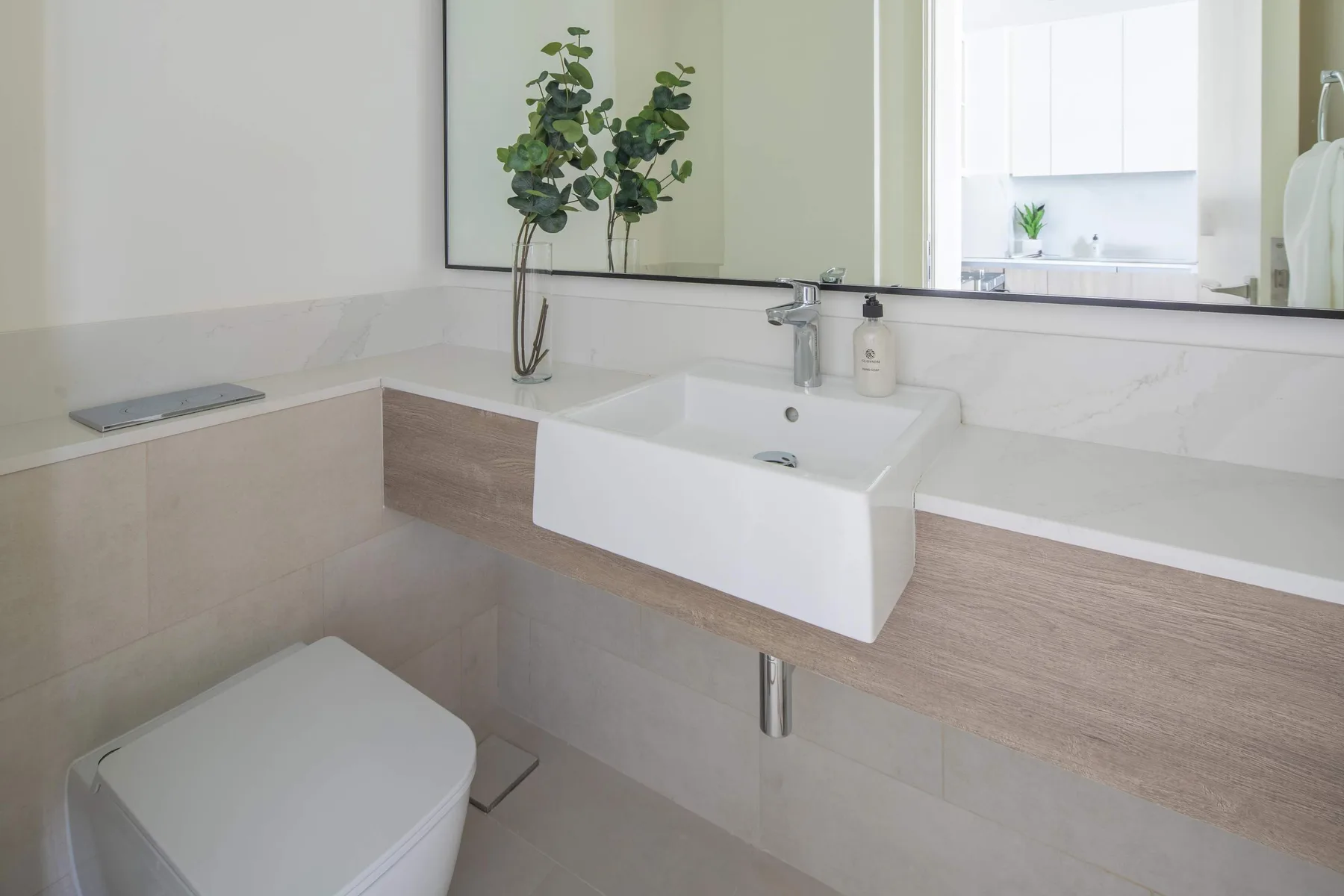 A bathroom vanity with a wall mirror, sink, and toilet.