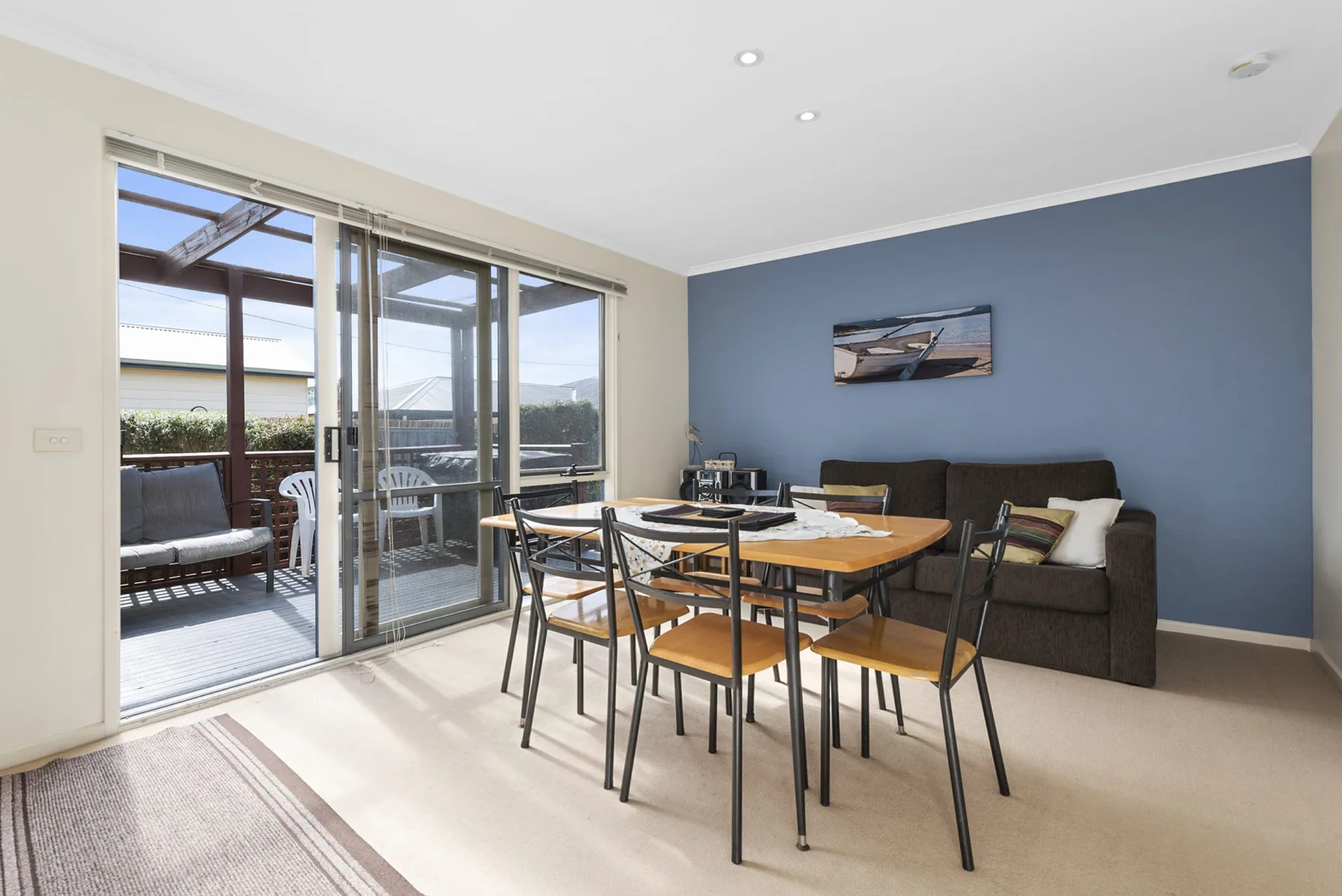 A dining and seating area opens onto a patio through large glass doors.