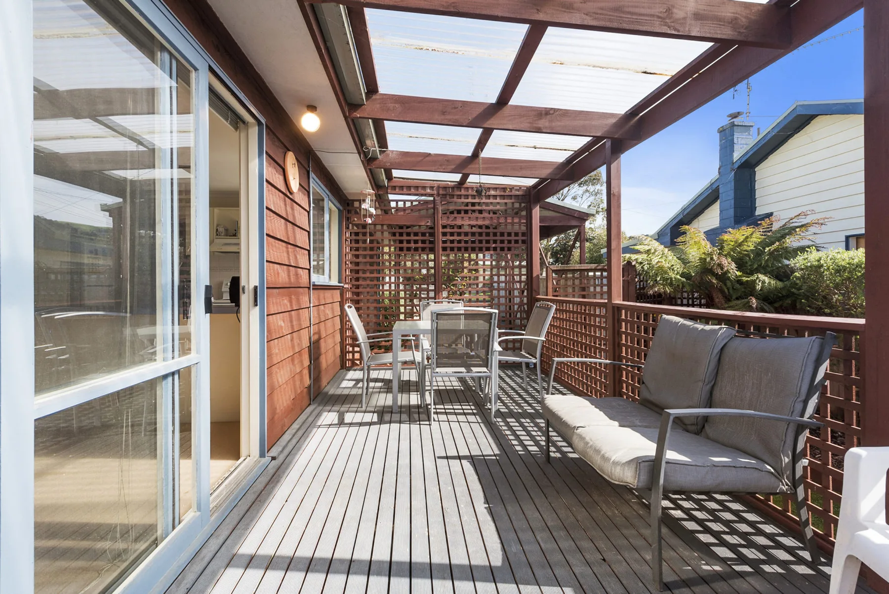 A covered outdoor deck with seating and a table.