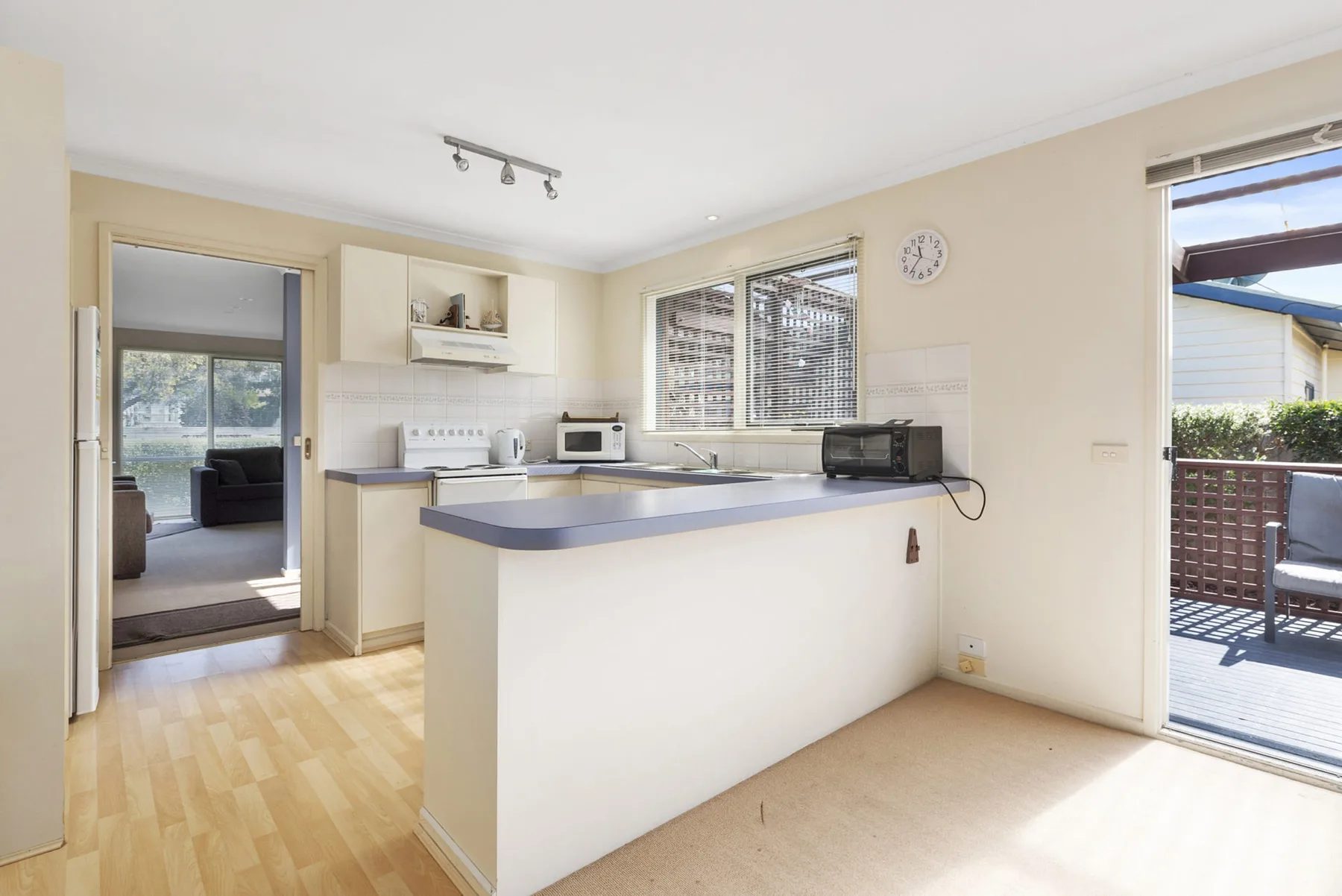 A bright kitchen with a central counter and windows overlooking the deck.