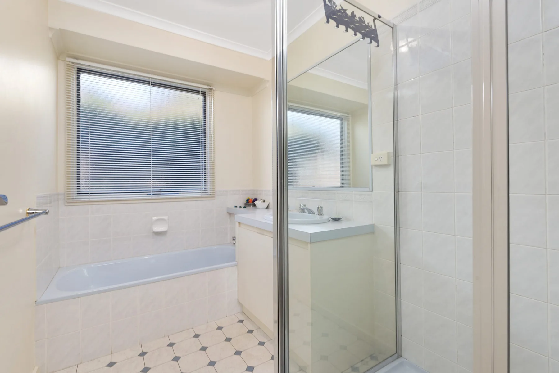 A bright bathroom with a bathtub, sink, and shower.