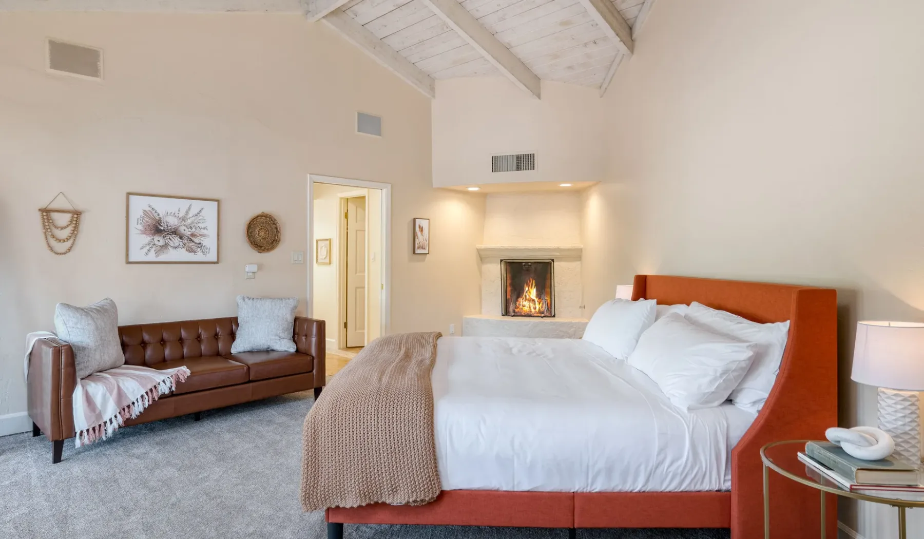 Un dormitorio con una cama grande, una zona de estar y una chimenea.