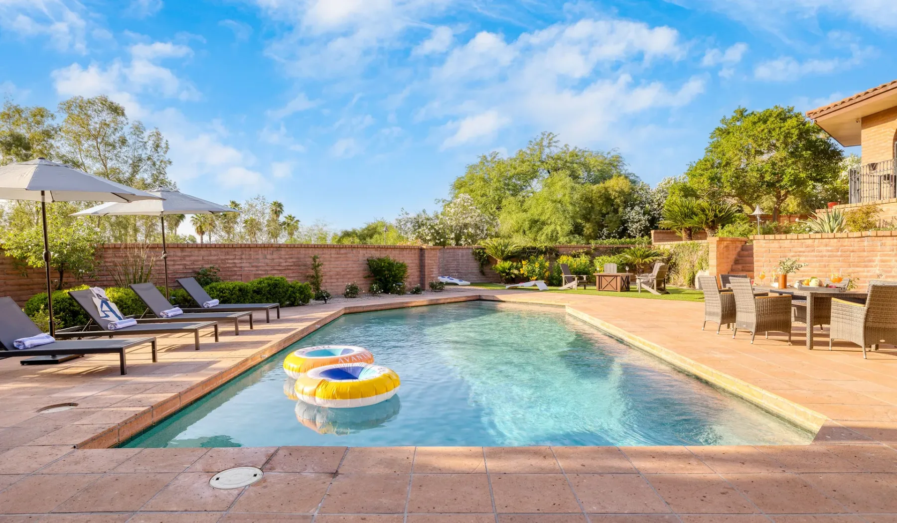 Una piscina al aire libre está rodeada de asientos y un patio.