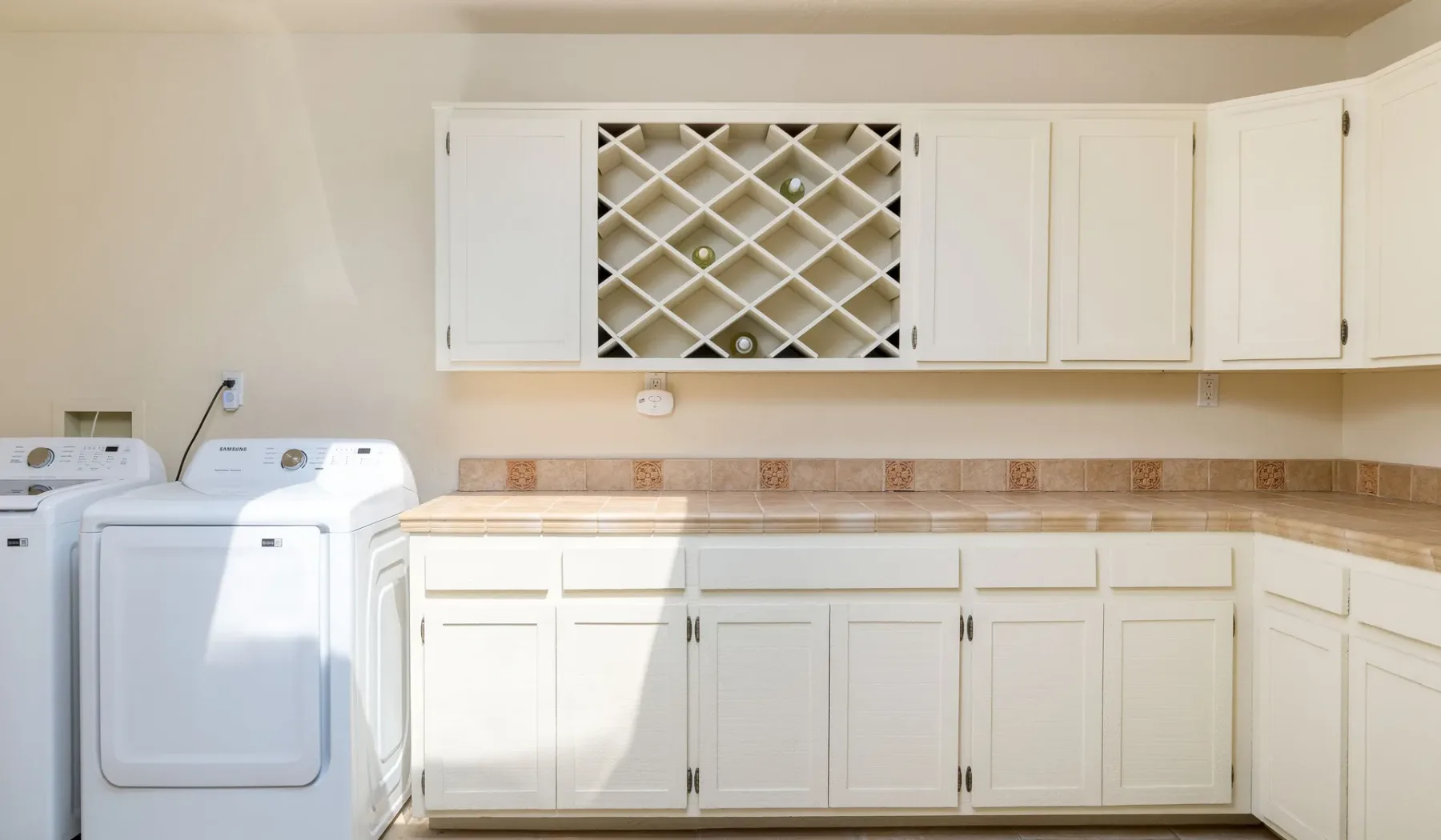 Un cuarto de lavandería con electrodomésticos blancos y armarios empotrados.