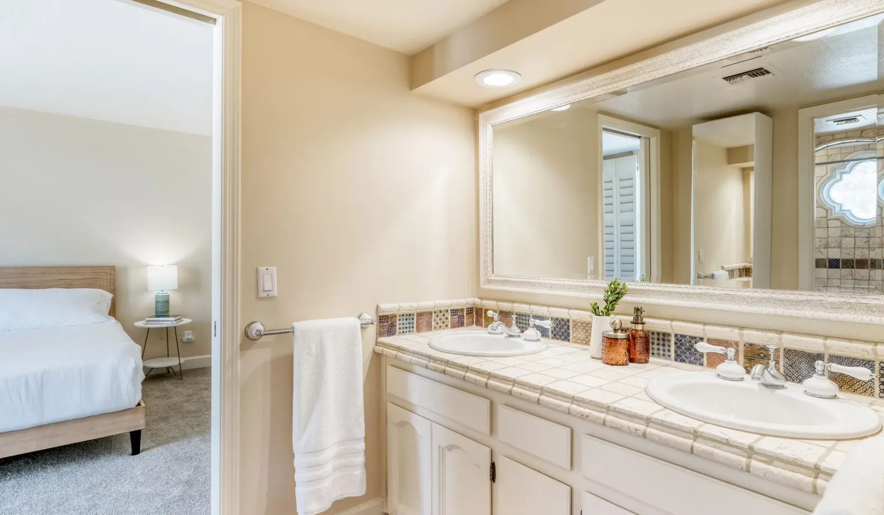 Un tocador de baño luminoso con dos lavabos y un espejo grande.