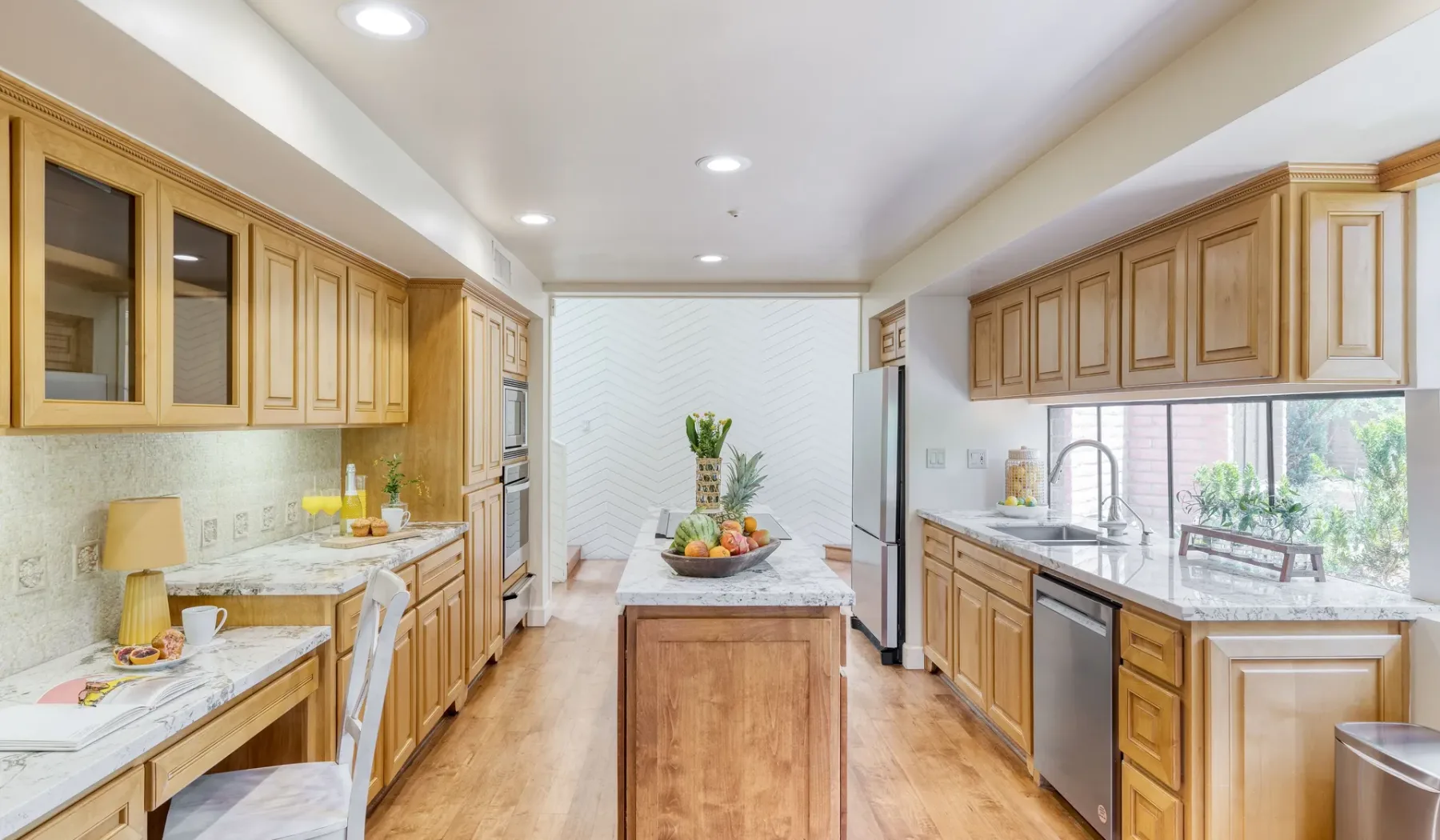 Una cocina luminosa con armarios de madera e isla central.