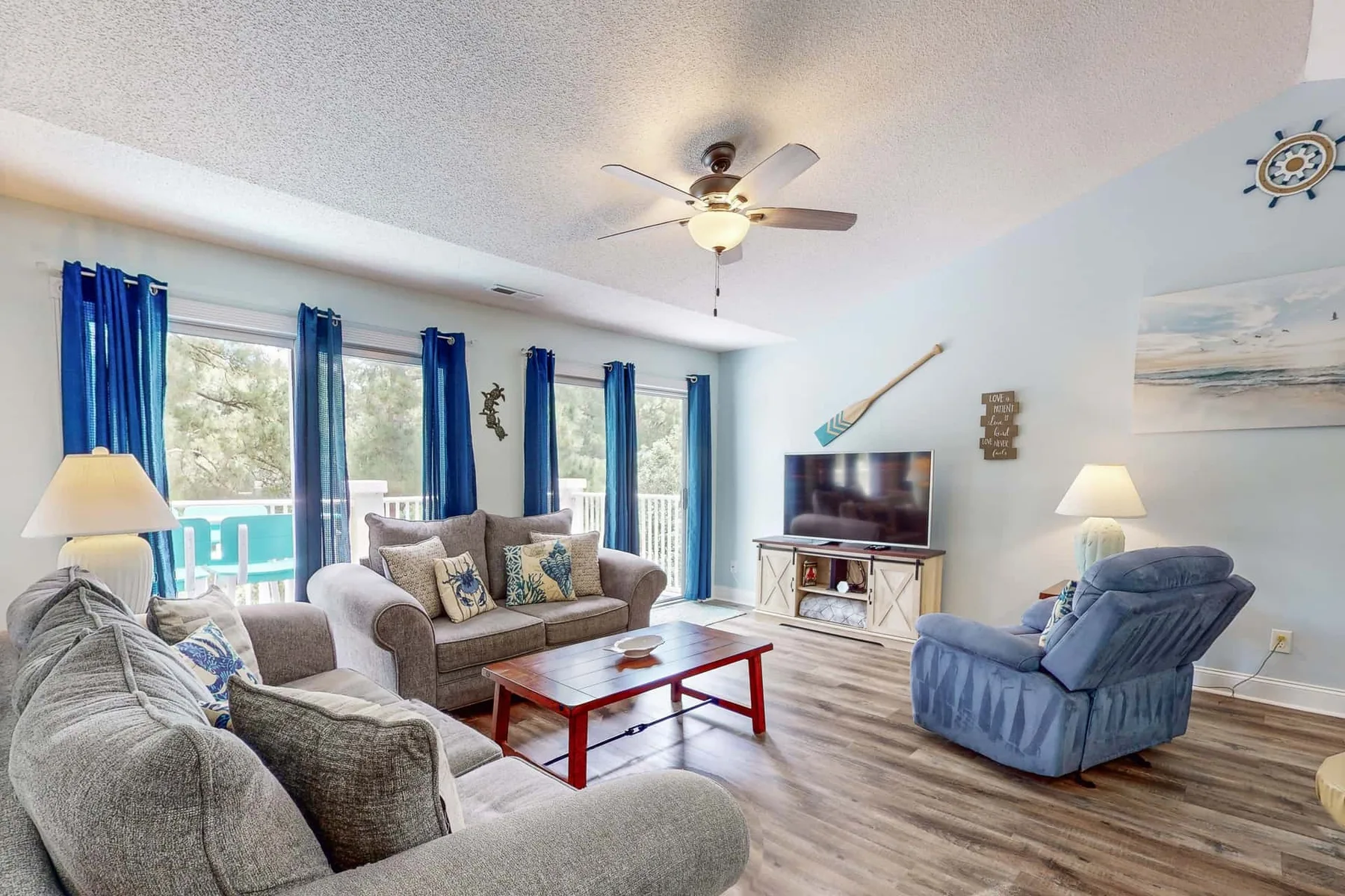 A living room with seating arranged around a coffee table and television.