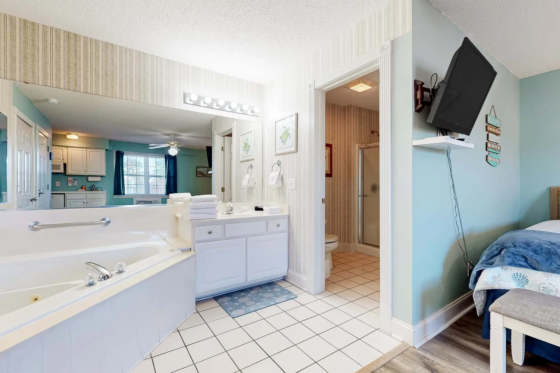 A bright bathroom with a bathtub, sink, and doorway to a shower.