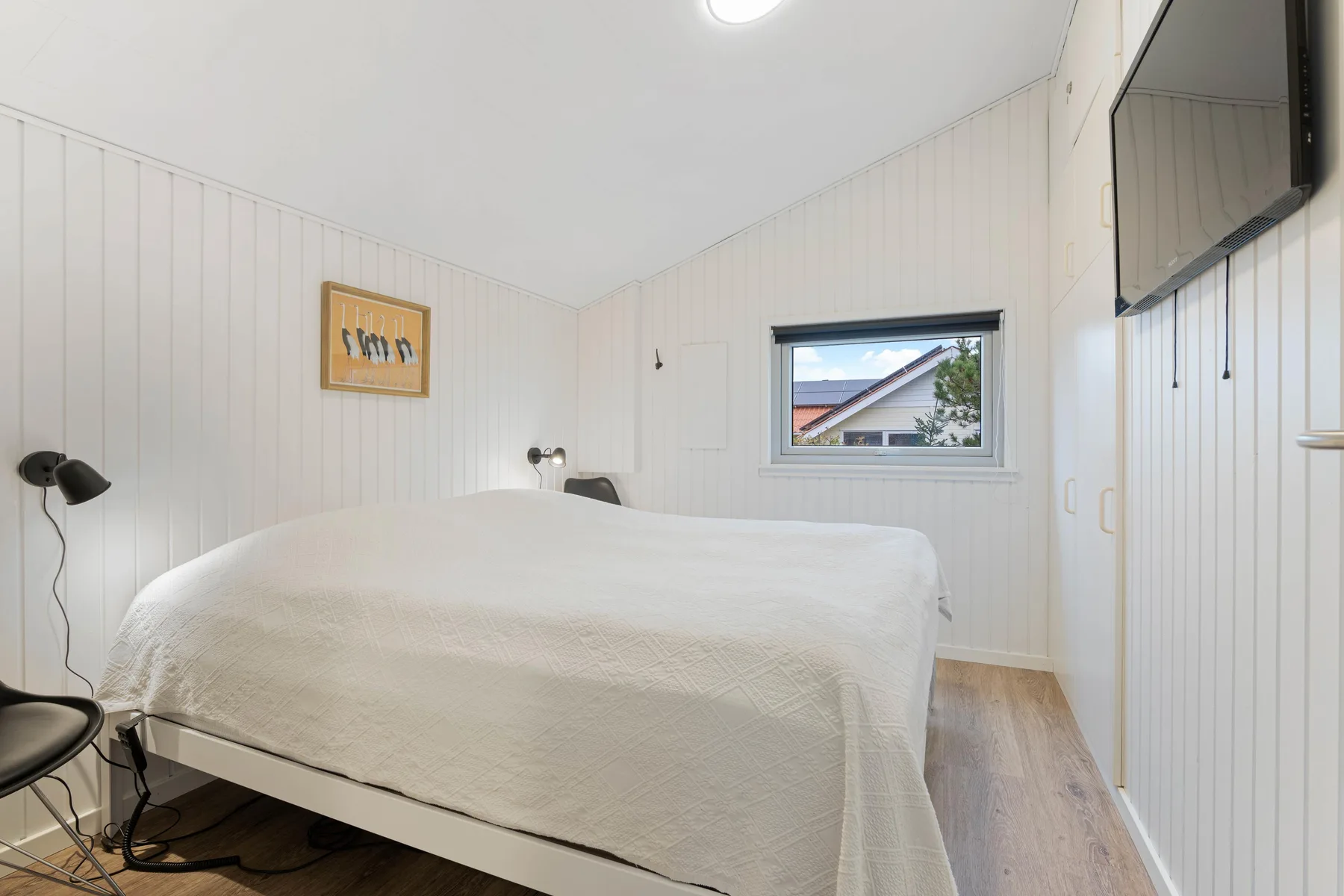 A bright bedroom with a large bed and a window.