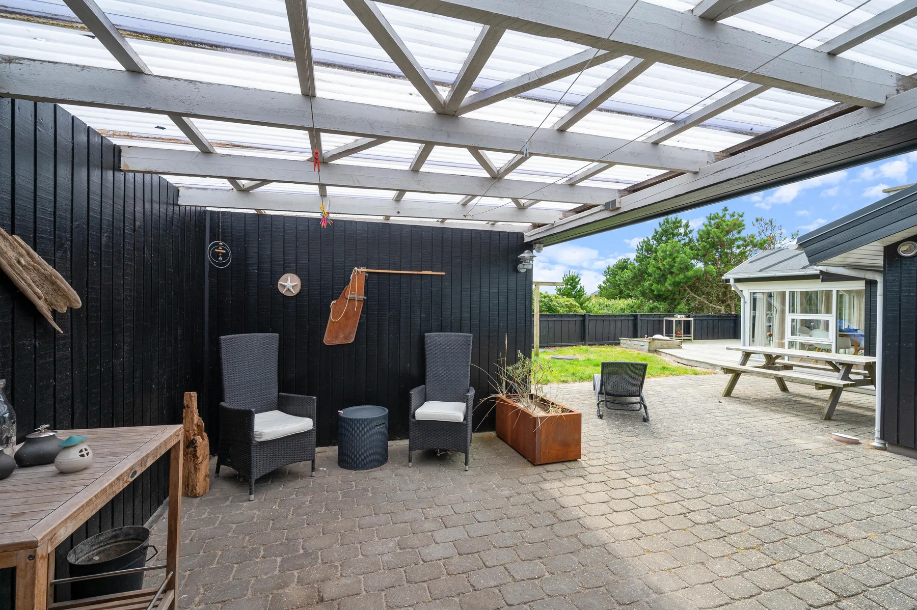 A covered patio with outdoor seating opens onto a paved courtyard.
