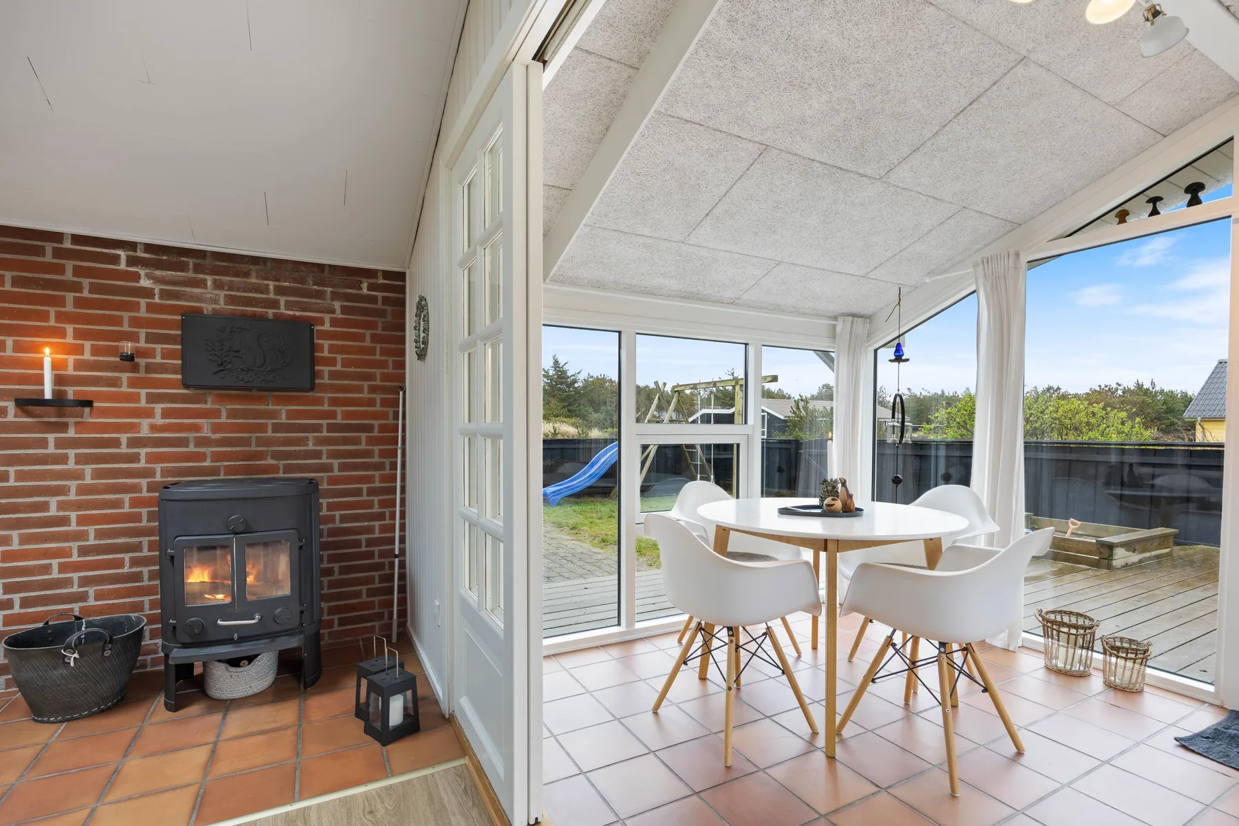 A bright dining area with a round table and large windows opening onto a patio.