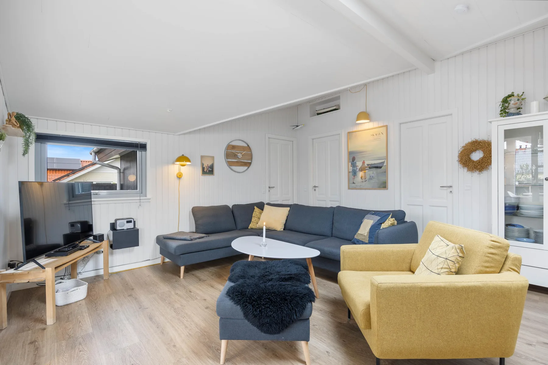 A bright living room with seating, a television, and a coffee table.