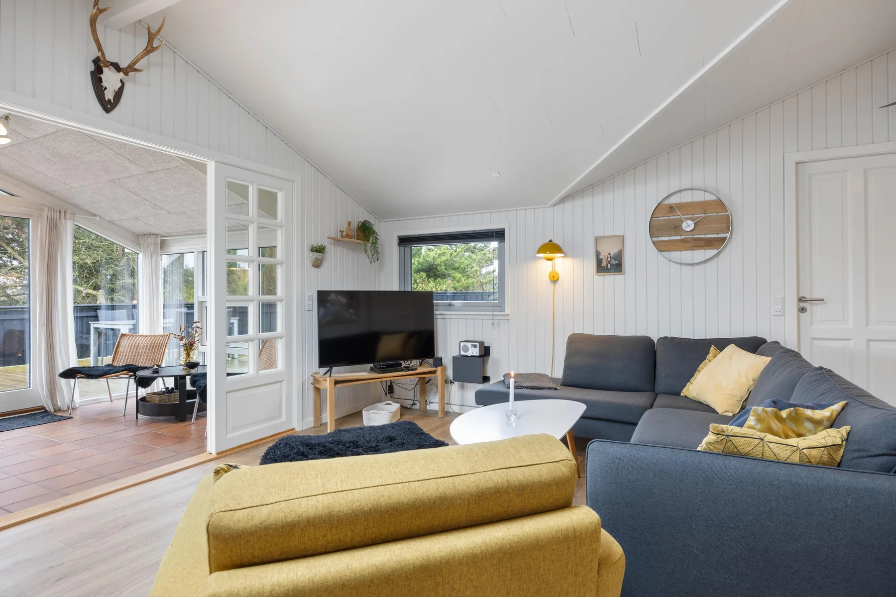 A living room with seating, a television, and a white coffee table.