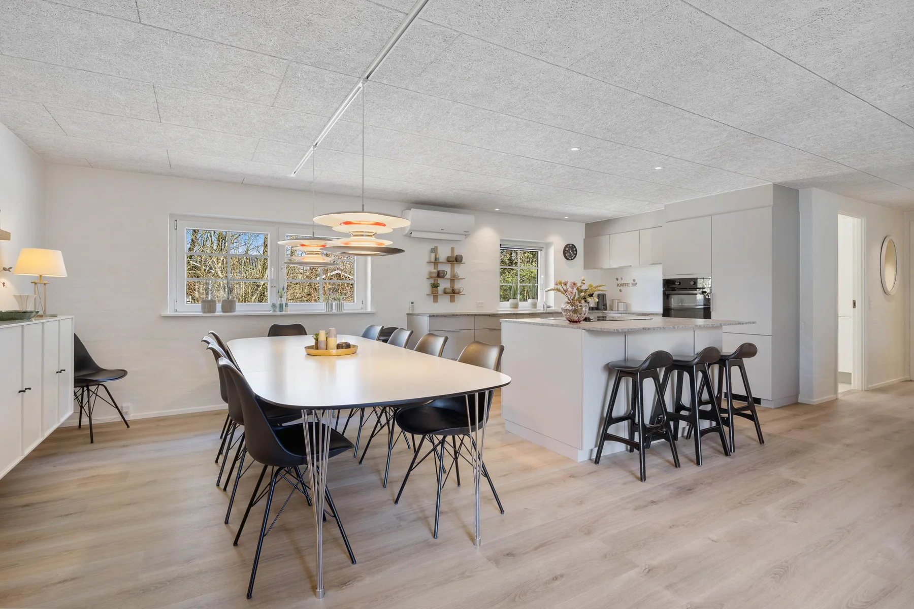 Una zona abierta de comedor y cocina con una mesa larga y una barra.