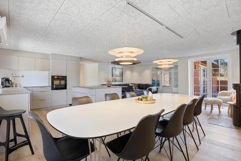 Cocina y comedor diáfanos con una mesa larga y asientos.