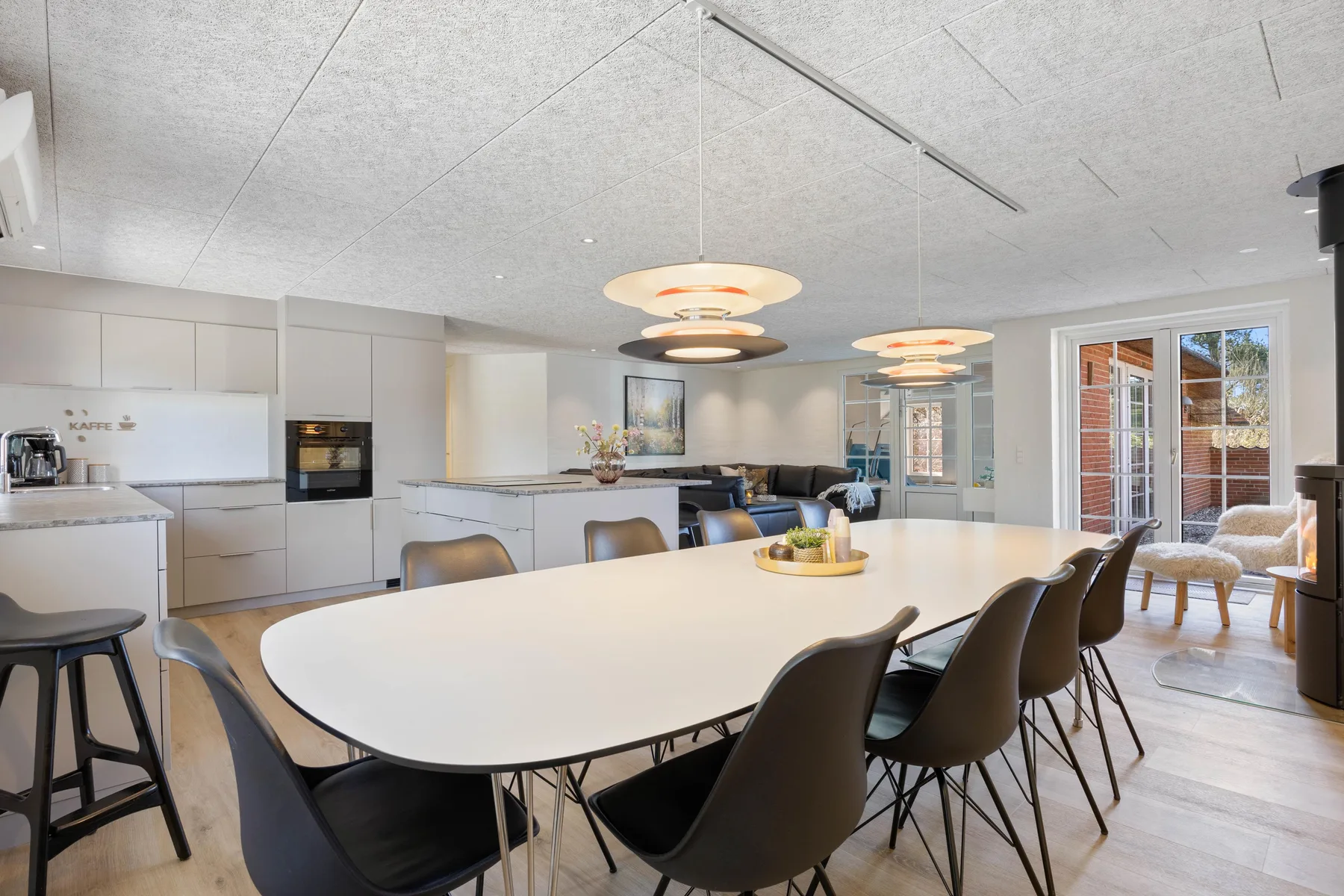 Una luminosa cocina-comedor de planta abierta con una mesa grande y asientos.