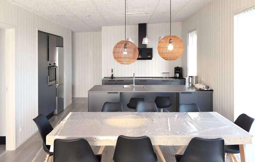Una cocina luminosa con comedor, una mesa grande y una isla.