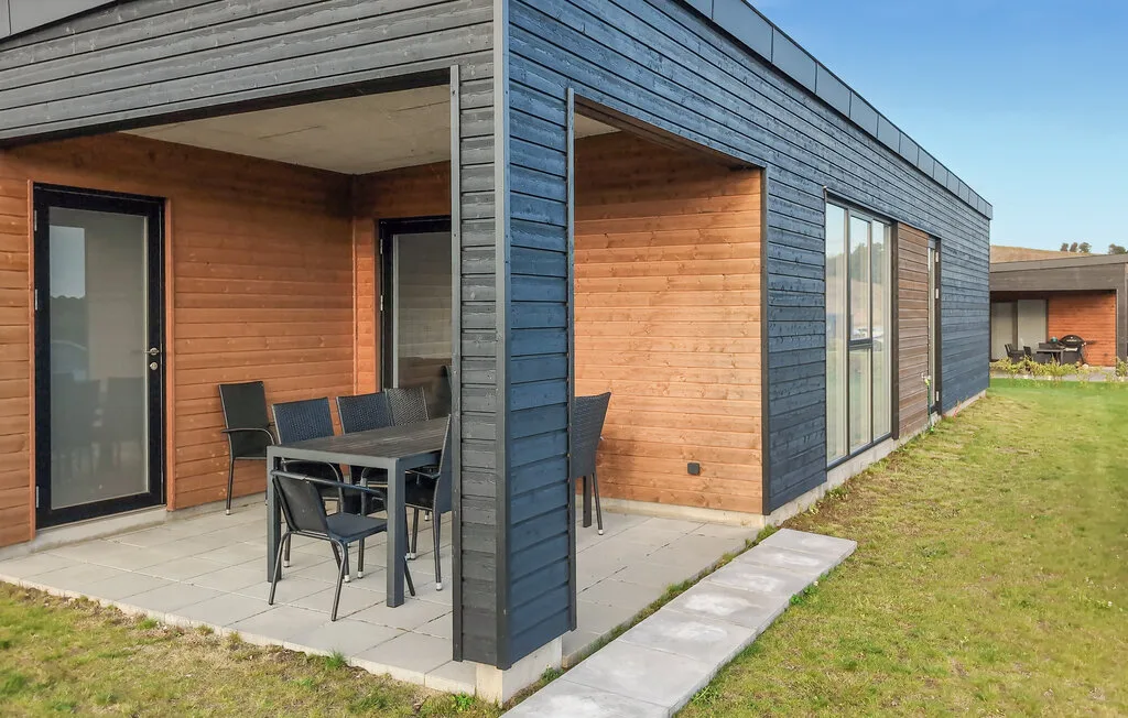 Exterior de un edificio moderno con un patio cubierto y asientos al aire libre.