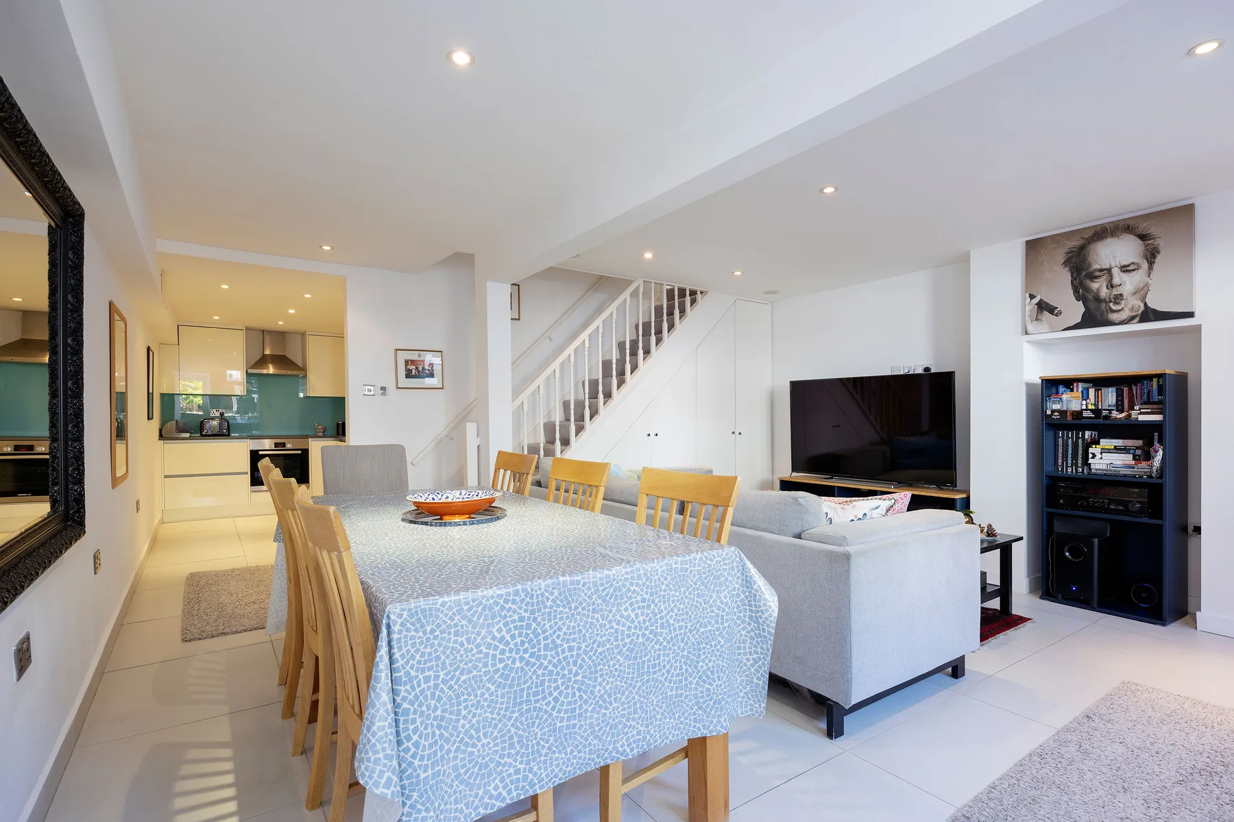 An open-plan dining and living area with a table, seating, and television.