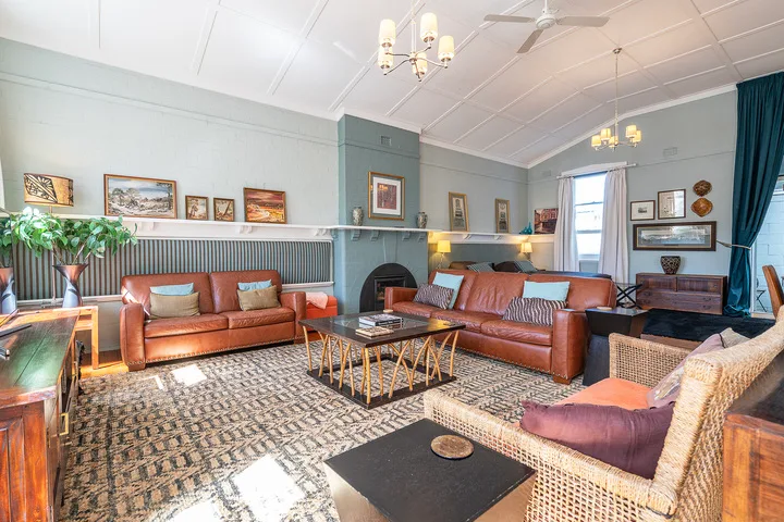 A living room with leather seating, patterned rugs, and a coffee table.