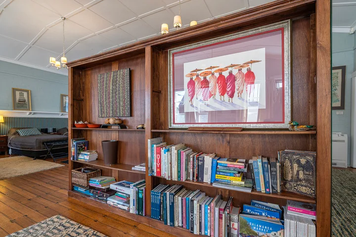 A wood-paneled living room with bookshelves and framed artwork.