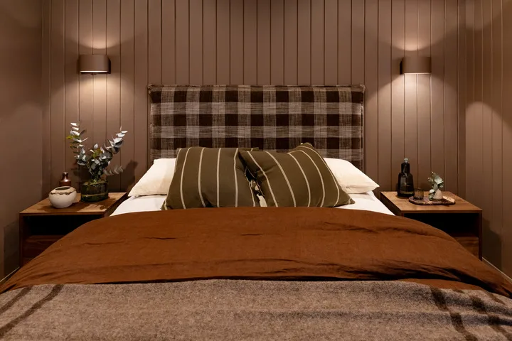A bedroom with a neatly made bed and matching bedside tables.