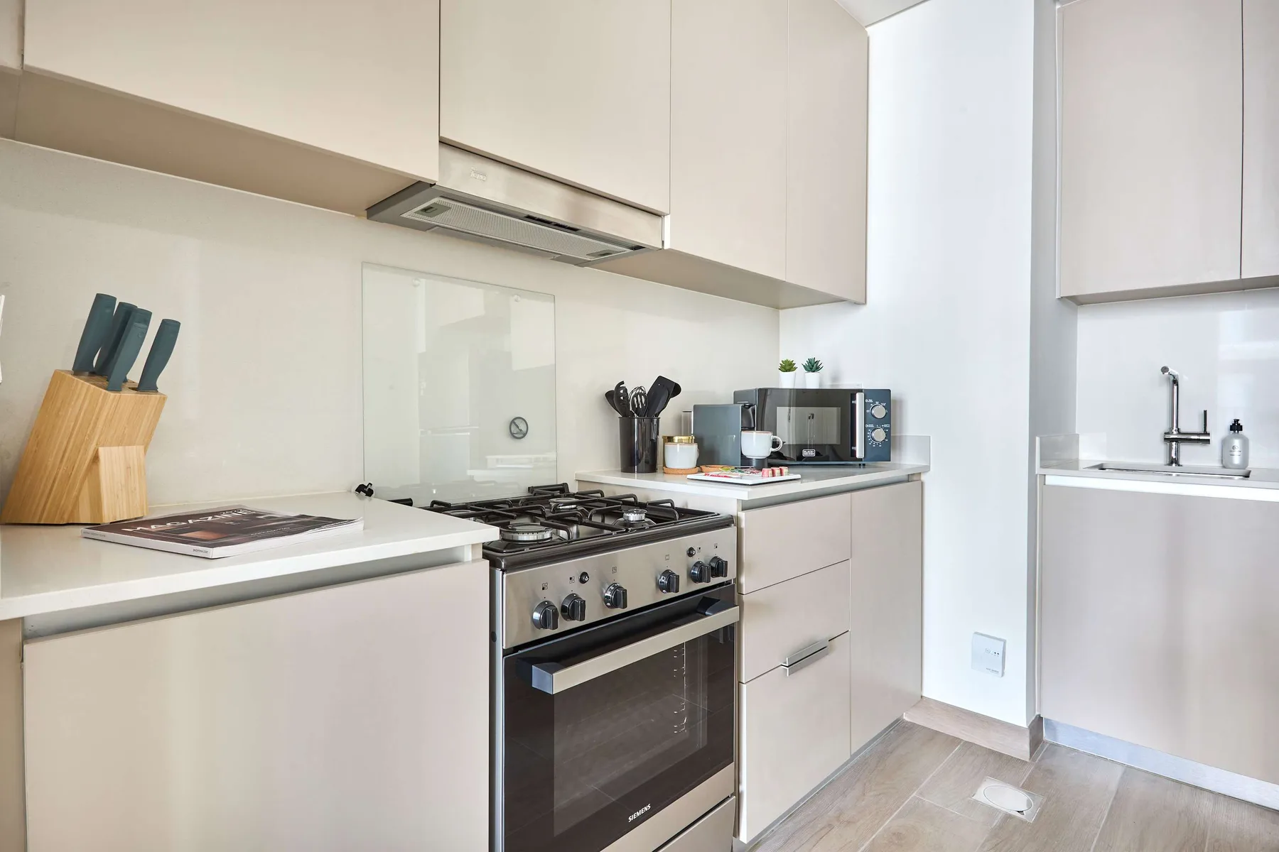 A bright modern kitchen with a gas cooktop and countertop appliances.