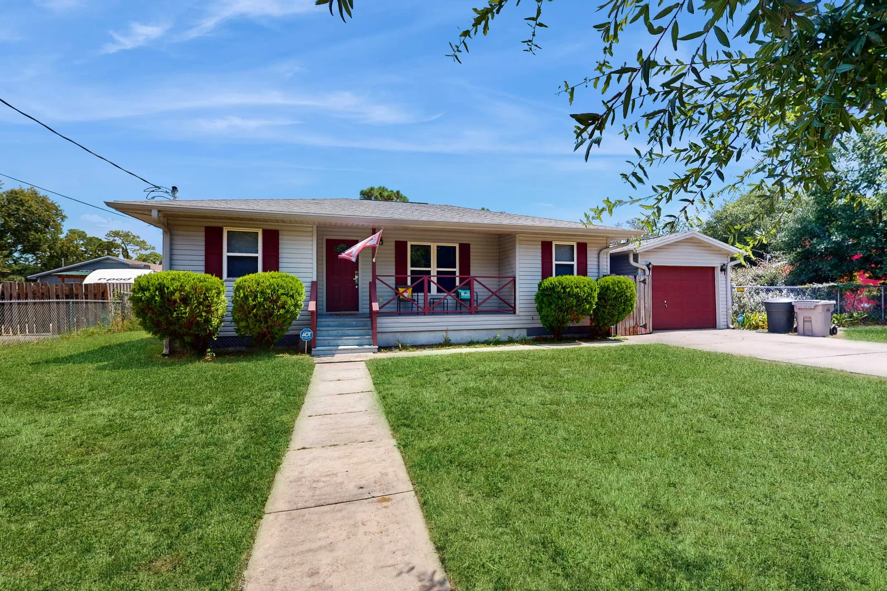 A single-story house with a front porch, lawn, and attached garage.