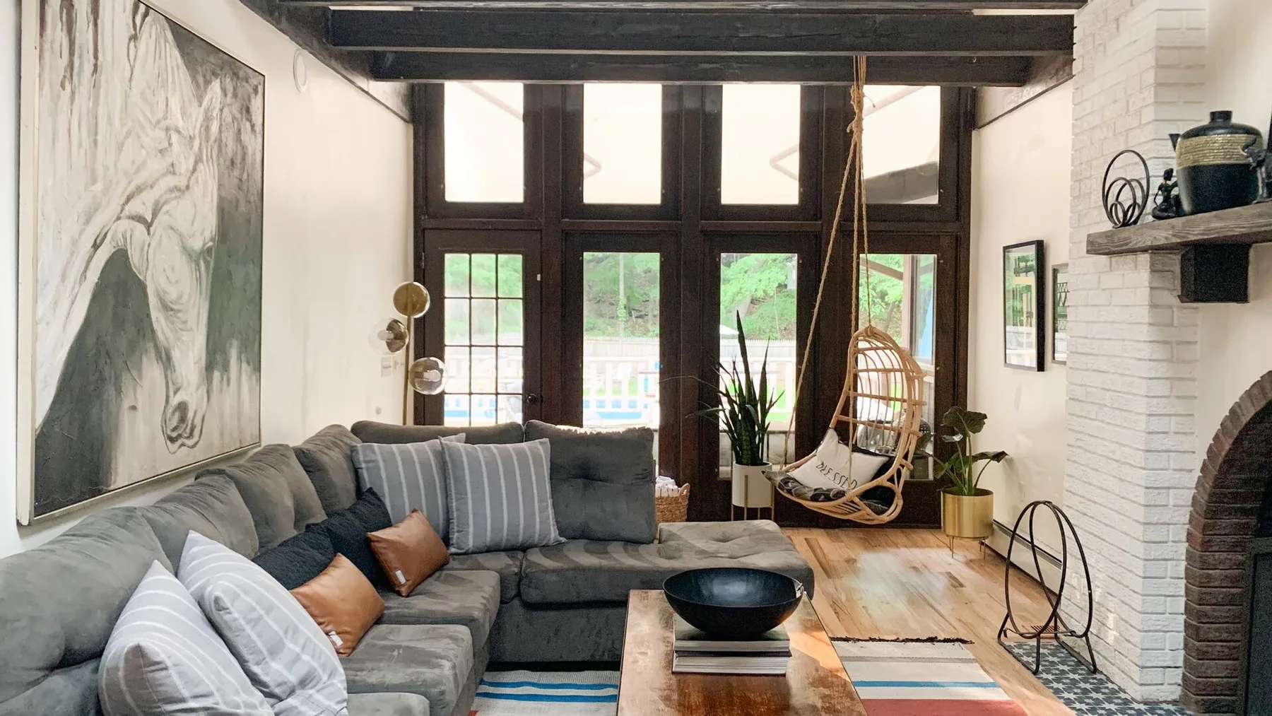 Una sala luminosa con una zona de asientos, ventanas altas y una chimenea.