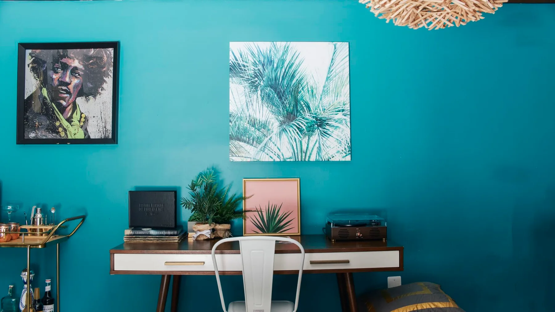 Una sala colorida presenta cuadros enmarcados sobre un escritorio con un tocadiscos.