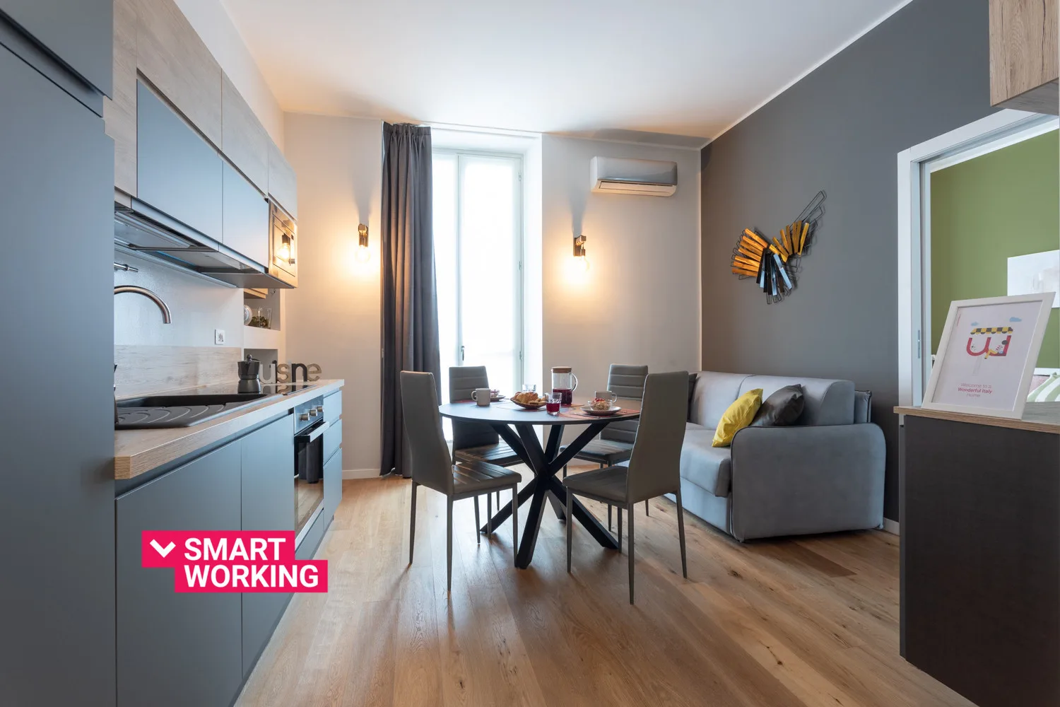 Una cocina compacta y zona de comedor con una mesa junto a una ventana y asientos.