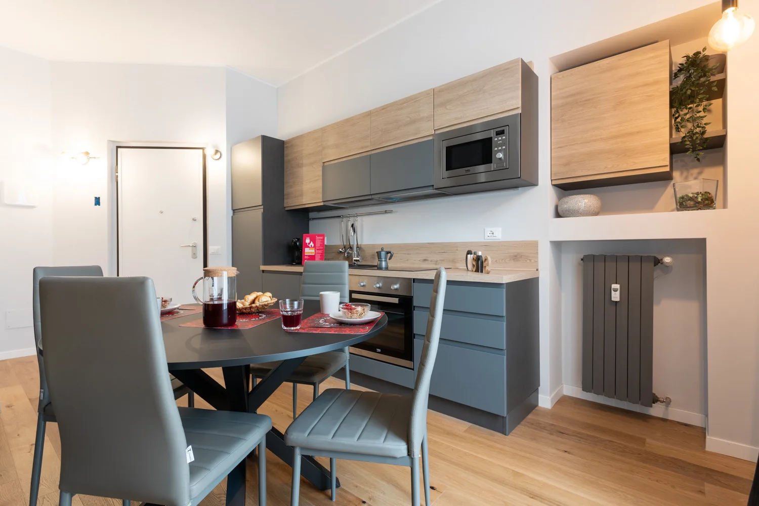 Comedor junto a una cocina compacta, con una mesa y sillas.