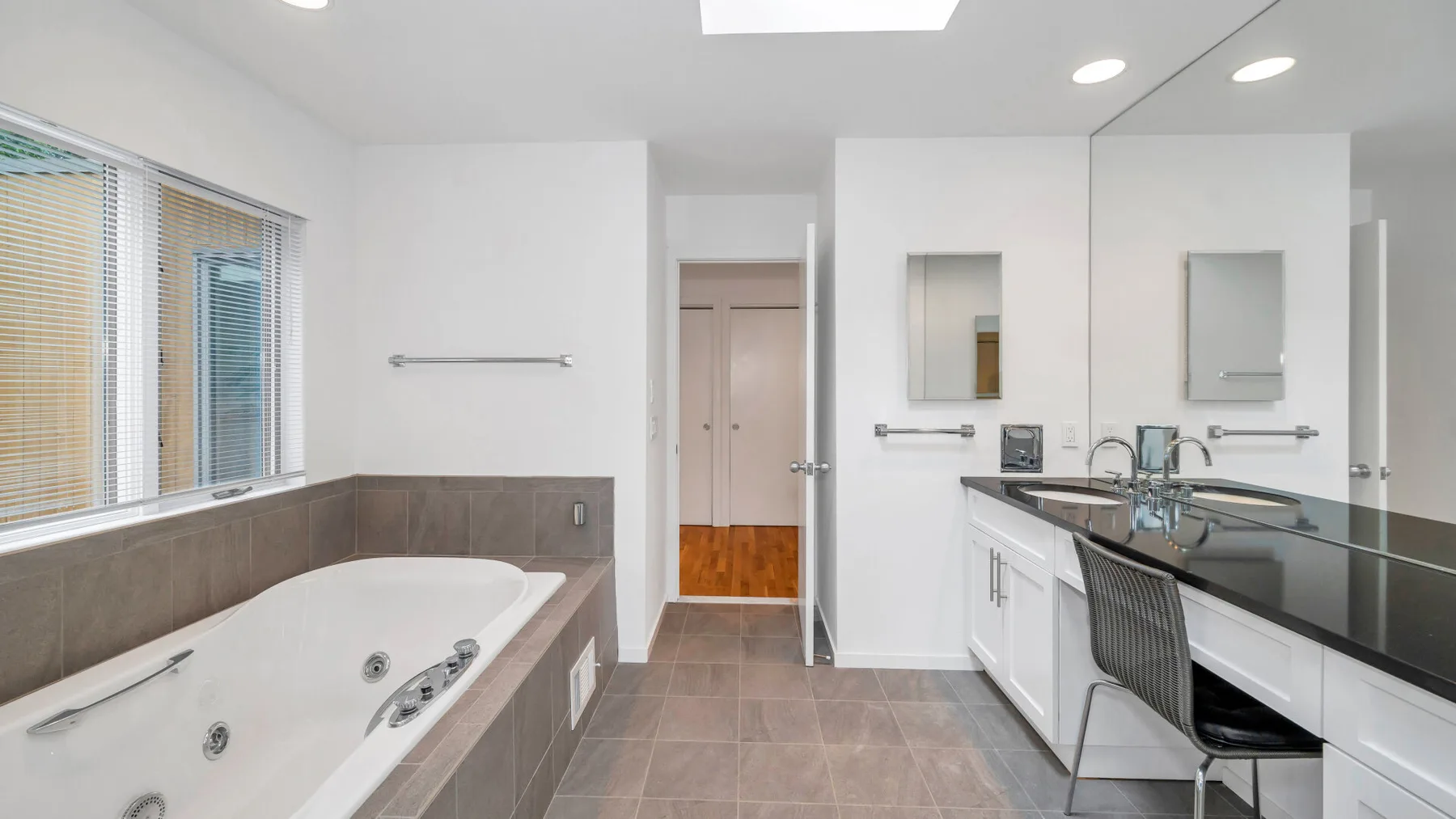 Un baño moderno con bañera empotrada y un amplio tocador.