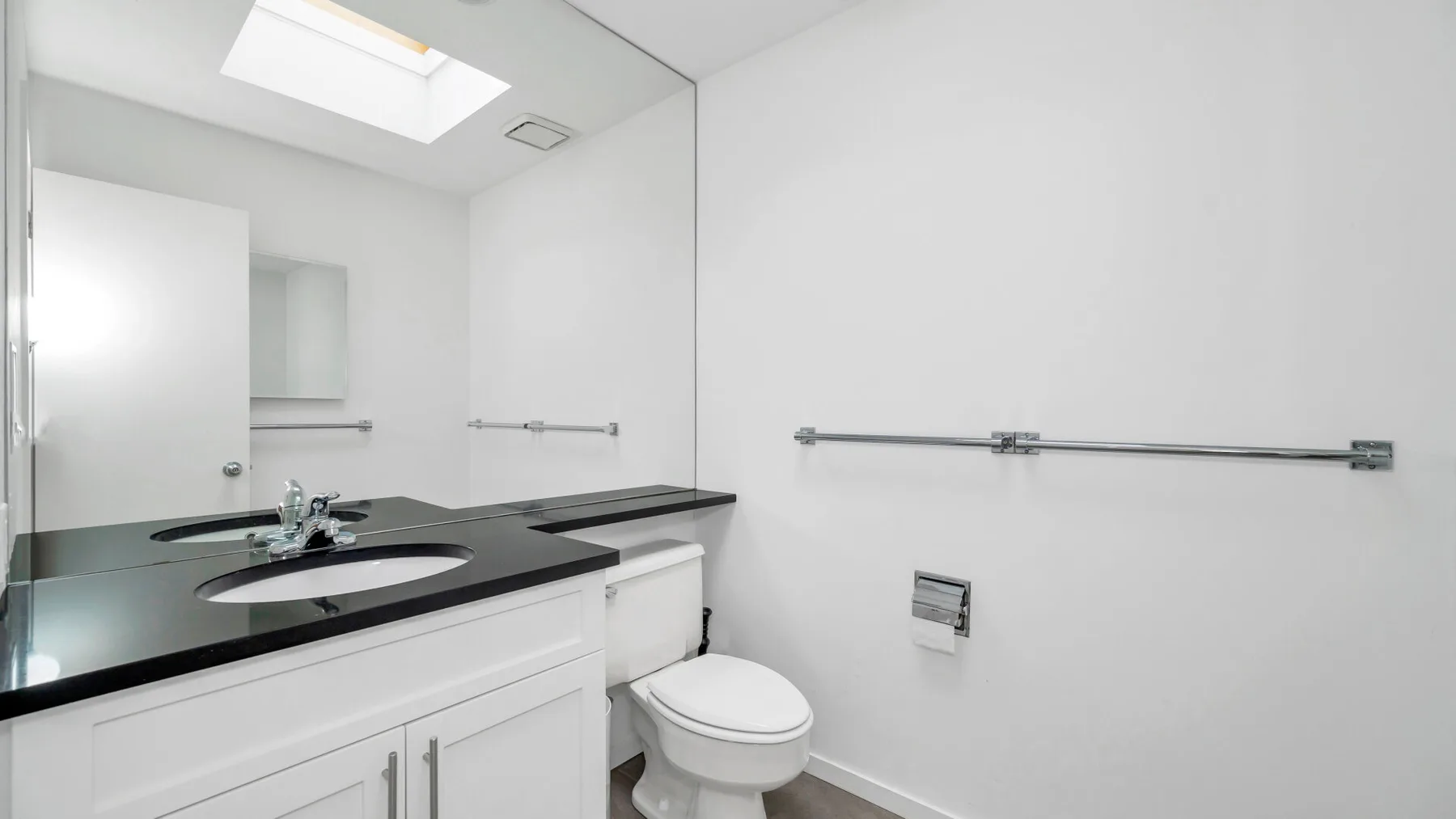 Un baño luminoso con lavabo y sanitario.