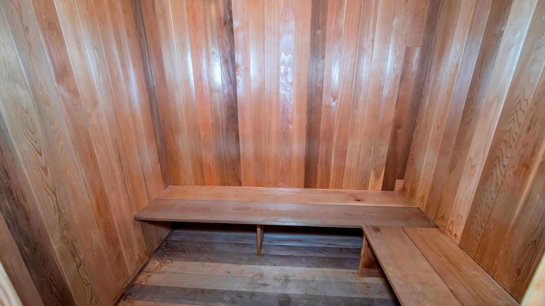 Interior de sauna revestido de madera con asientos escalonados.